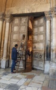 A Muslim keyholder prepares to lock the Holy Sepulchre door (Seetheholyland.net)