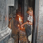 Lighting candles on girder that braced the Tomb of Christ before restoration in 2017 (Seetheholyland.net)