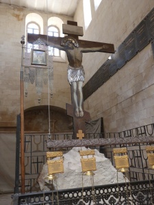 Crucifix standing over piece of rock of Calvary (Seetheholyland.net)
