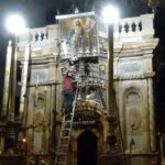 Late at night, oil lamps on the front of the edicule are topped up. (Seetheholyland.net)