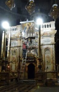 Late at night, oil lamps on the front of the edicule are topped up. (Seetheholyland.net)