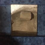 View into venerated cave from above through metal grille (© Gregory Jenks)